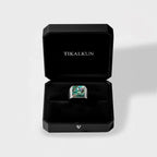 Ring with an abalone shell stone in a black Tikalkun box on a light gray background