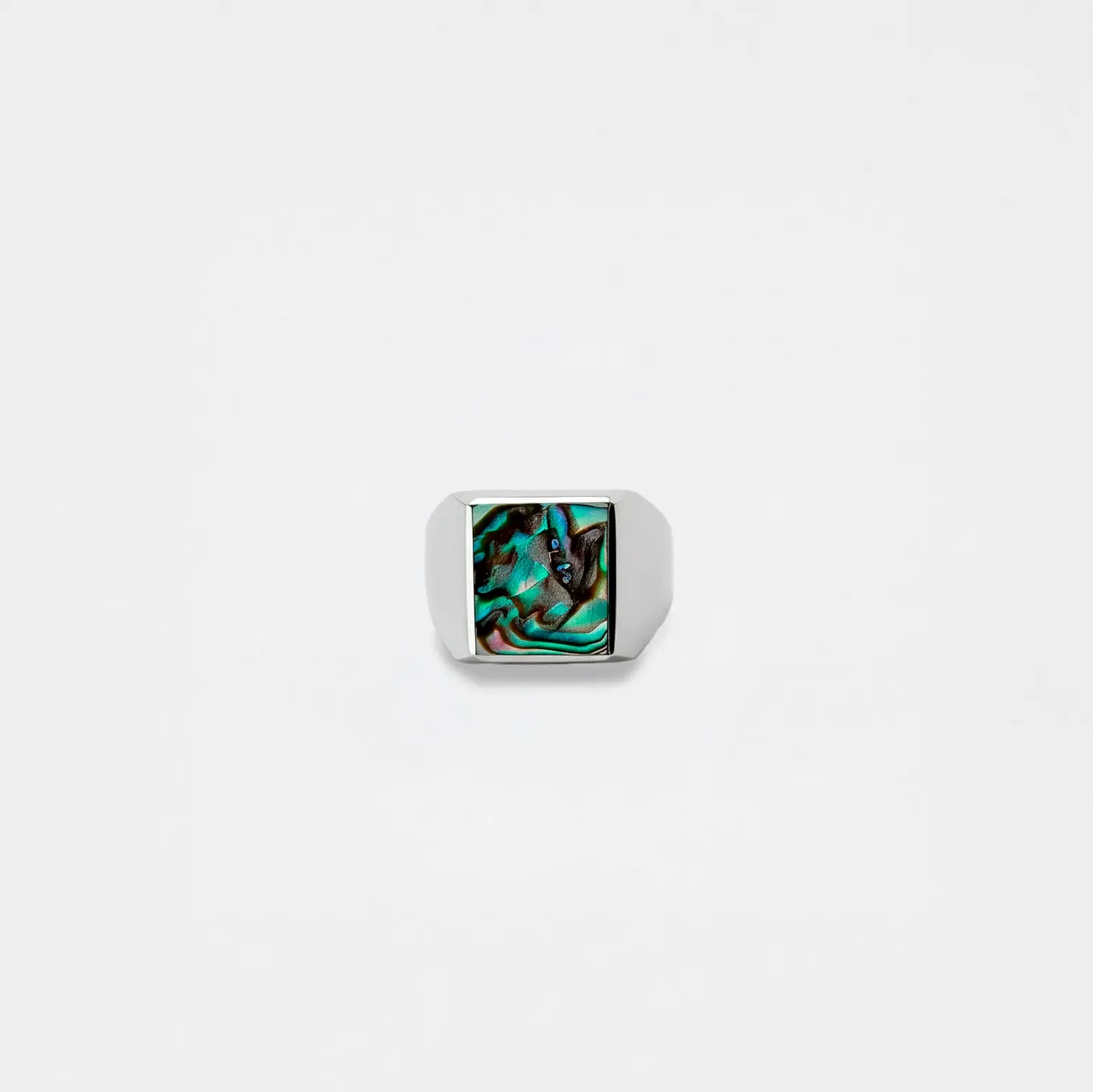 Silver ring with an abalone shell stone on a white background