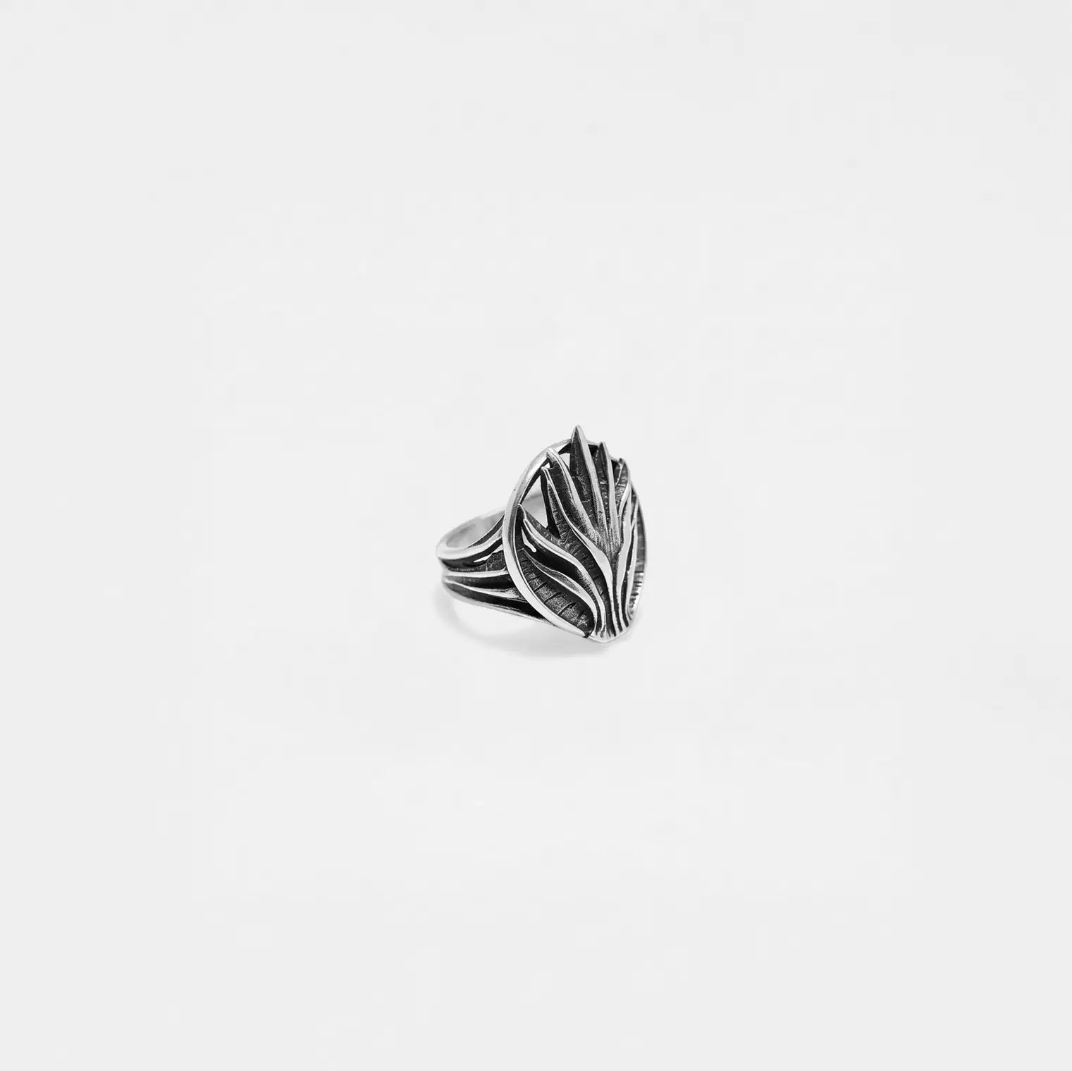 Silver agave ring with leaf design on a light gray background