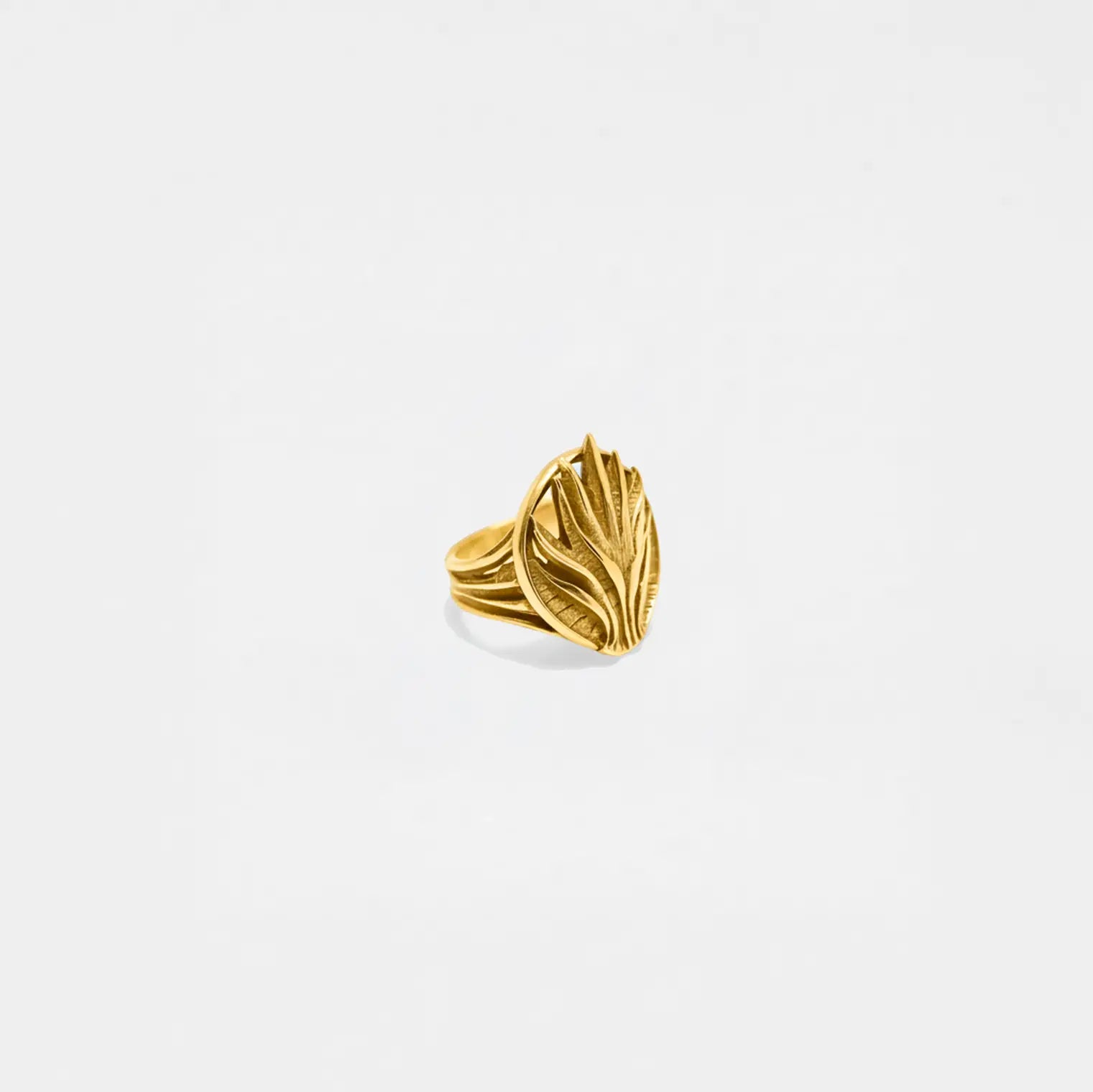 Gold agave ring with leaf design on a light gray background