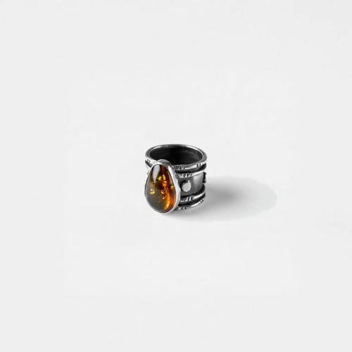 Silver ring with a amber stone on a white background