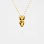 Gold Anubis pendant necklace on a white background