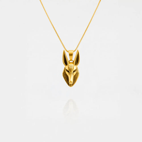 Gold Anubis pendant necklace on a white background