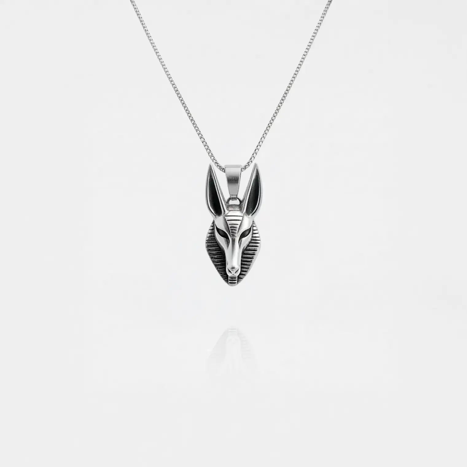 Silver Anubis pendant necklace on a light gray background