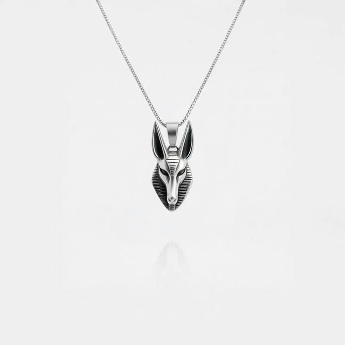 Silver Anubis pendant necklace on a light gray background
