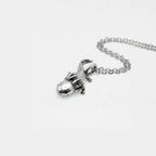 Silver axolotlpendant on a chain against a white background