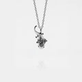 Silver AXOLOTL-shaped pendant on a chain against a white background
