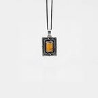 Necklace with a rectangular pendant featuring amber on a white background