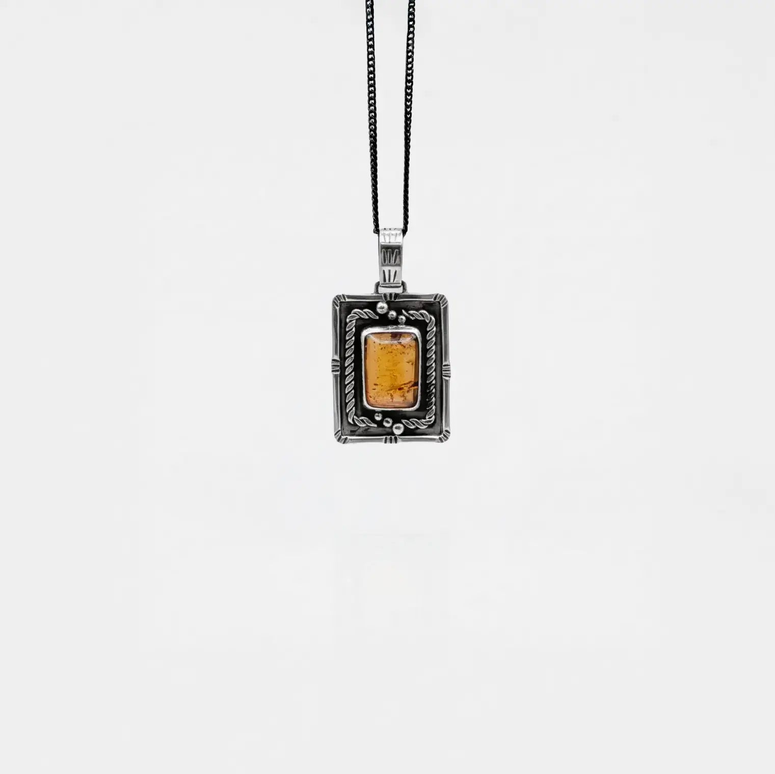 Necklace with a rectangular pendant featuring amber on a white background