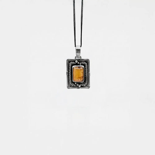 Necklace with a rectangular pendant featuring amber on a white background