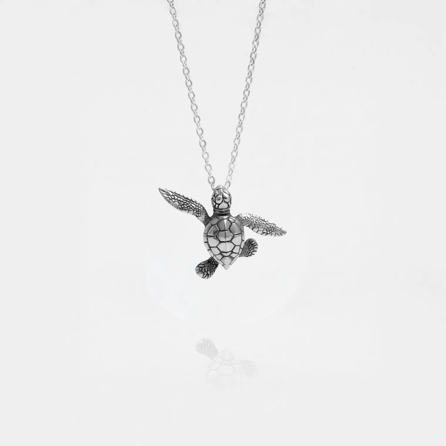 baby turtle silver pendant on a white background
