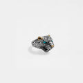 Jaguar head ring with gold accents and turquoise stones on a light gray background