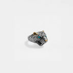 Jaguar head ring with gold accents and turquoise stones on a light gray background