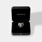 Silver jaguar ring with turquoise eyes in a black Tikalkun box on a light gray background