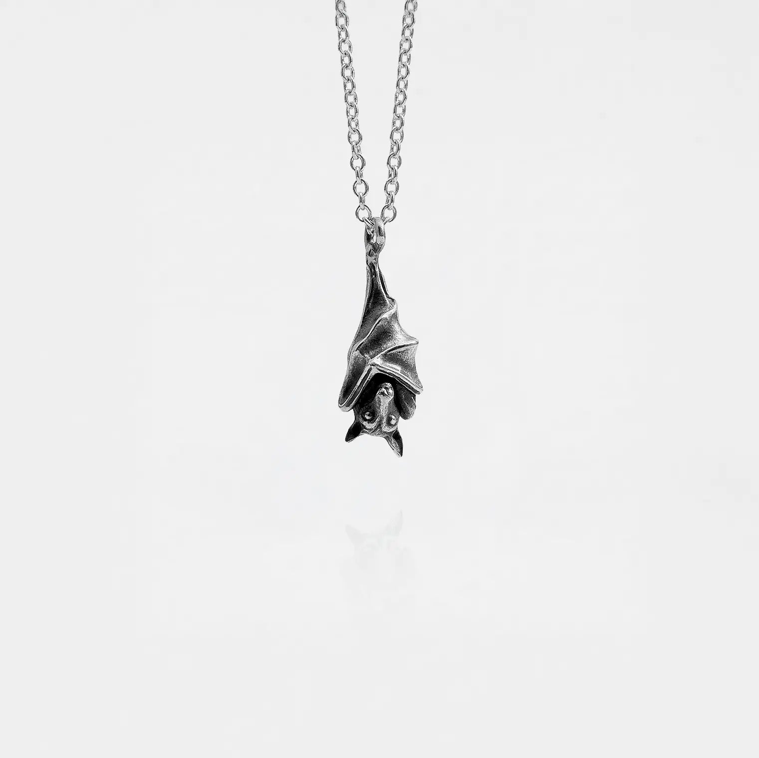 Silver bat pendant necklace on a white background