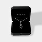 Silver necklace with a bat pendant on a black Tikalkun jewelry box against a white background