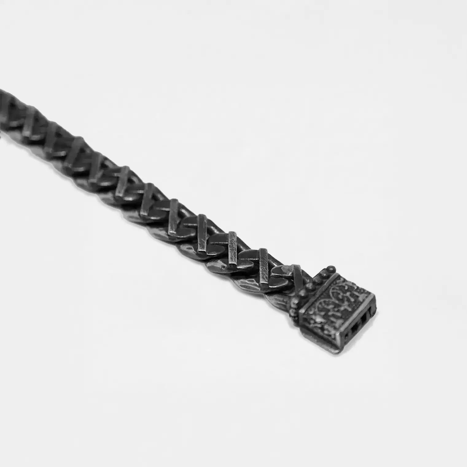 Close-up of a black chain bracelet on a light gray background