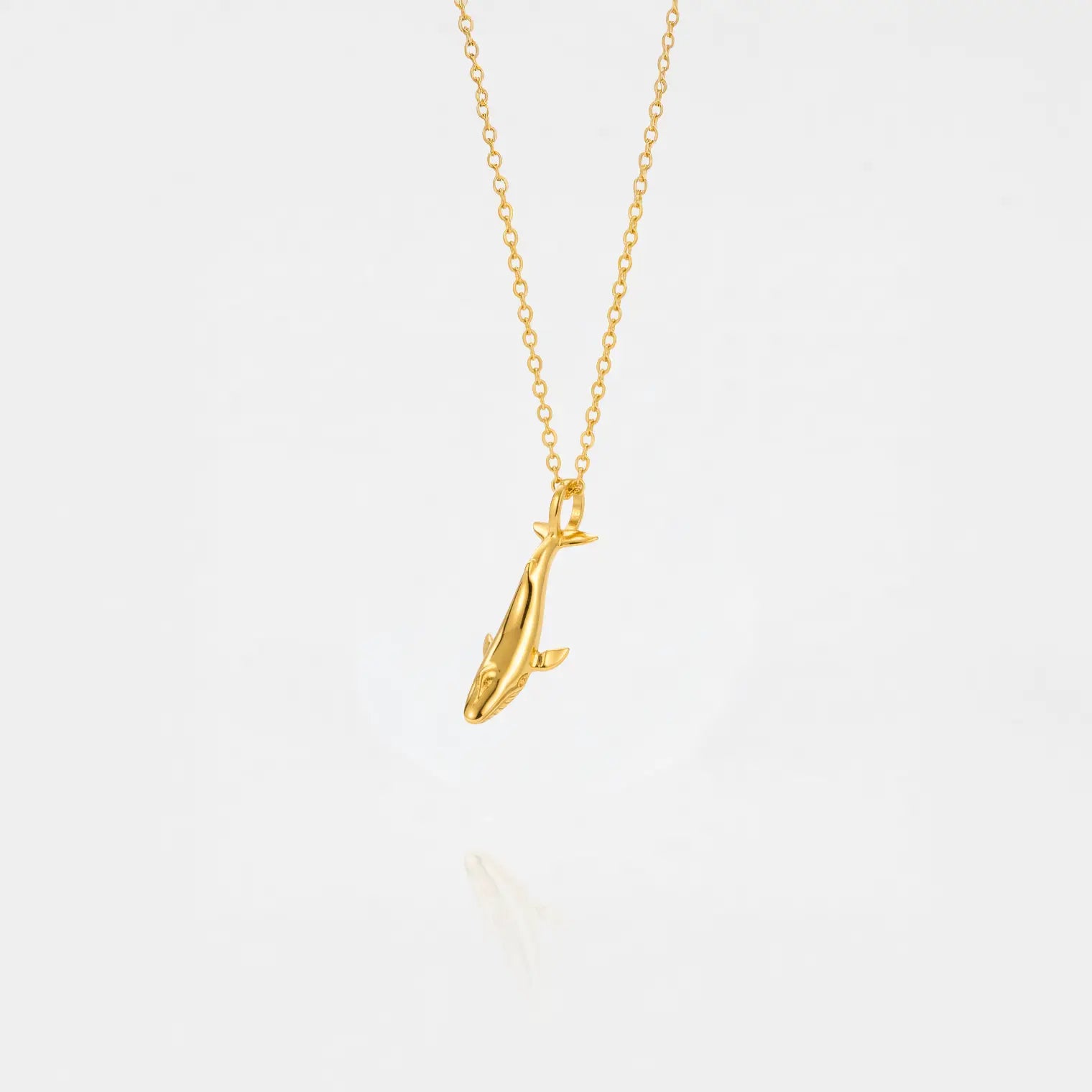 Blue-whale gold pendant on a white background