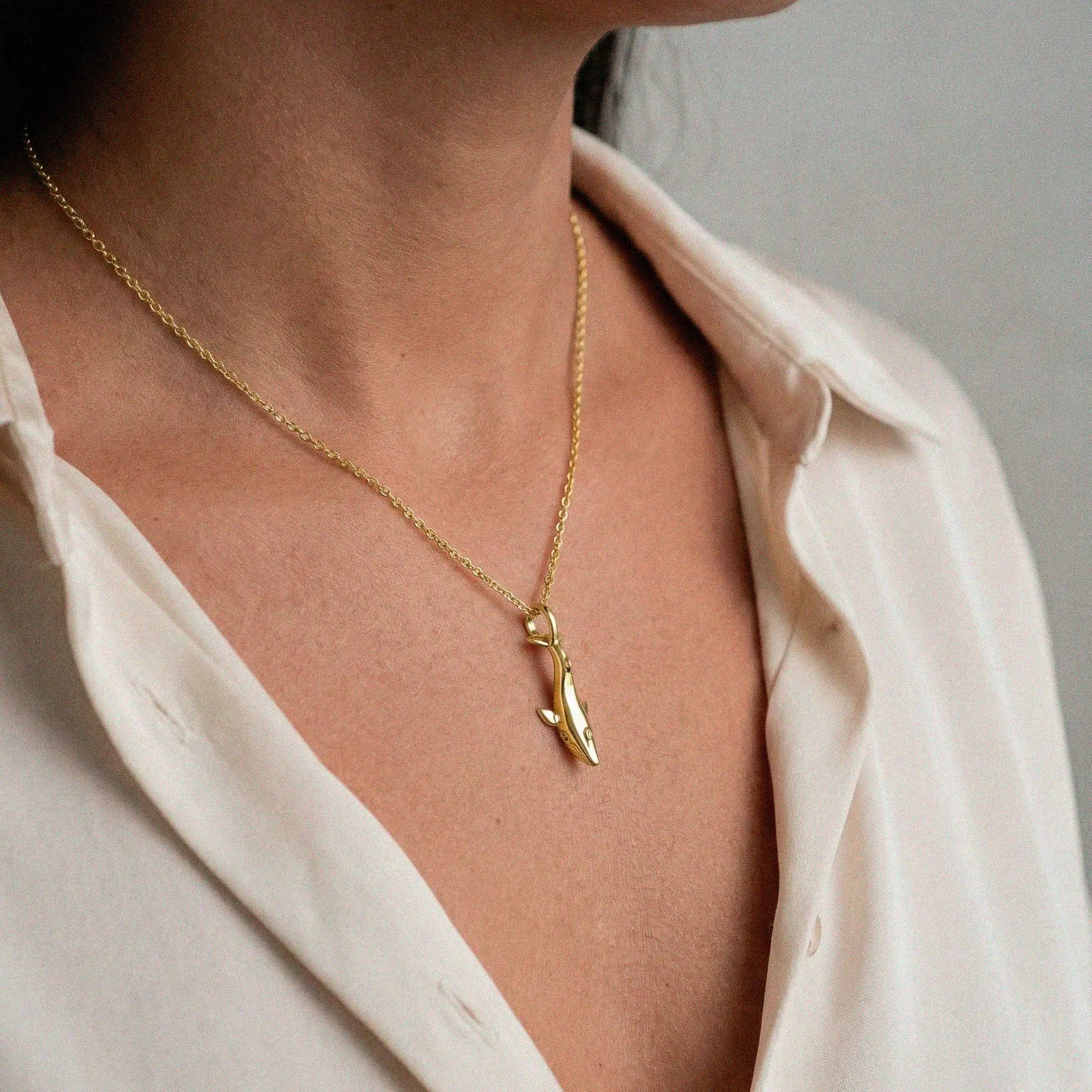 woman wearing a Blue-whale gold pendant on a white background