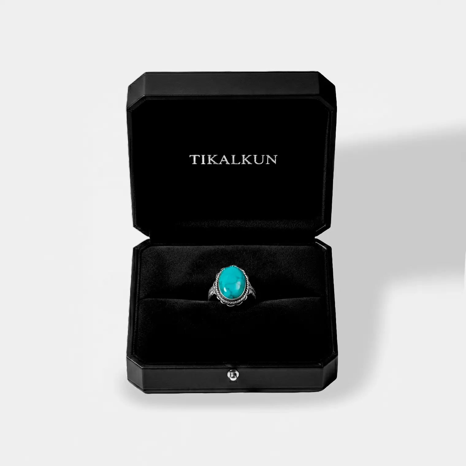Turquoise ring in a black Tikalkun jewelry box on a light gray background