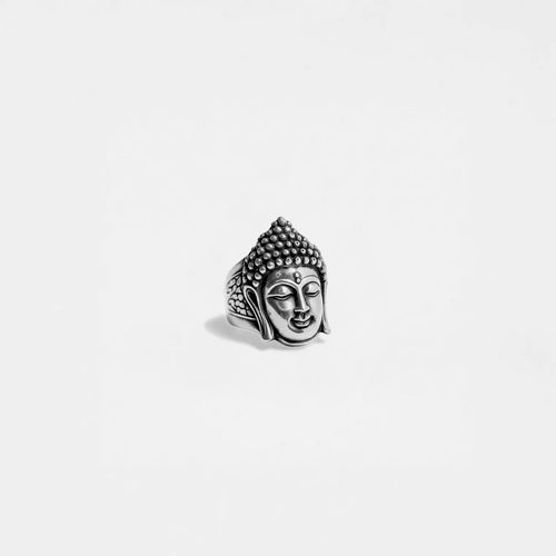 Silver Buddha head ring on a light gray background