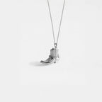 Silver cowboy boot pendant on a white background