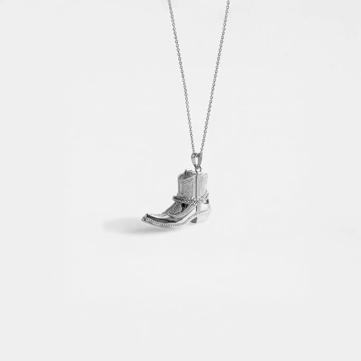 Silver cowboy boot pendant on a white background