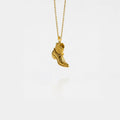 gold cowboy boot pendant on a white background