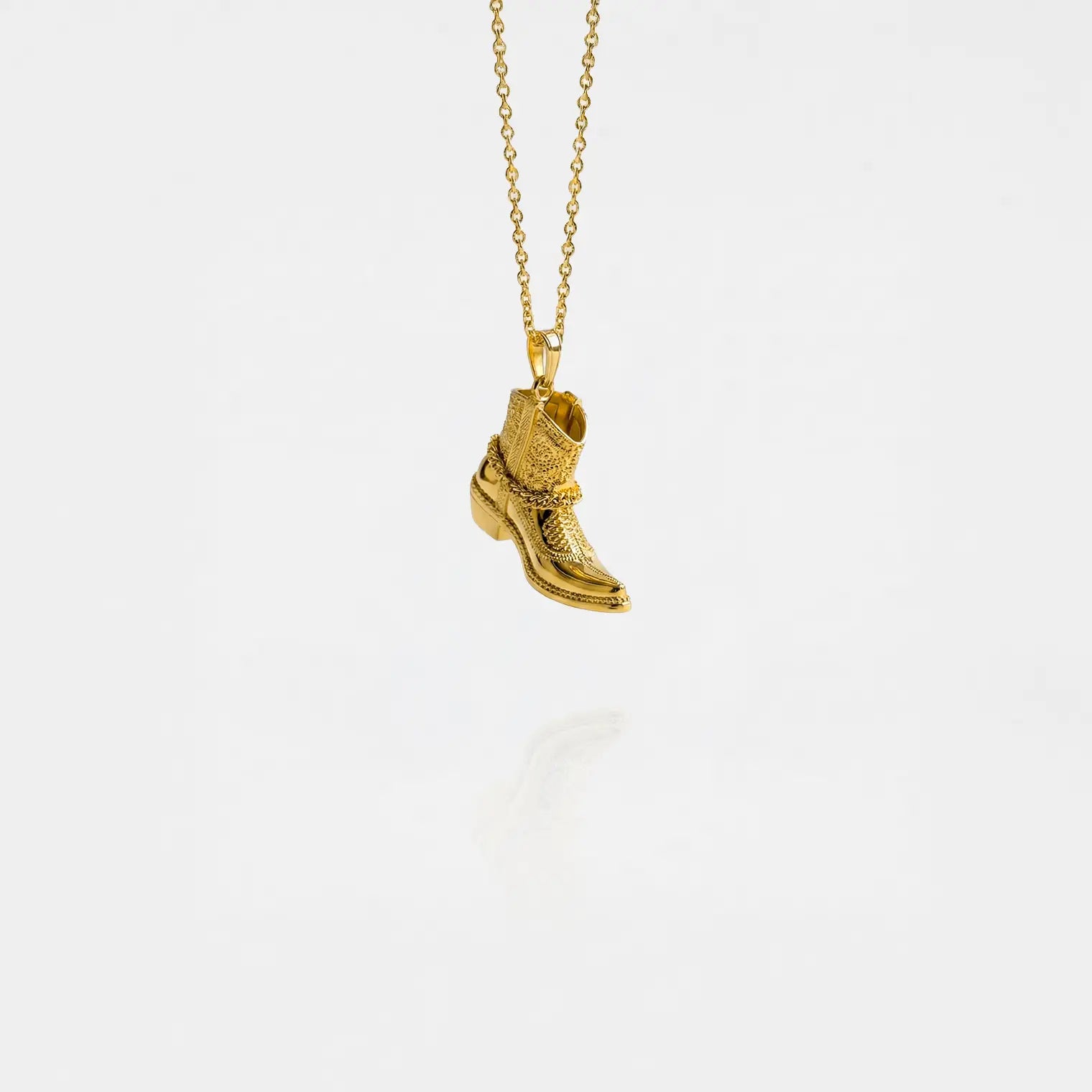 gold cowboy boot pendant on a white background