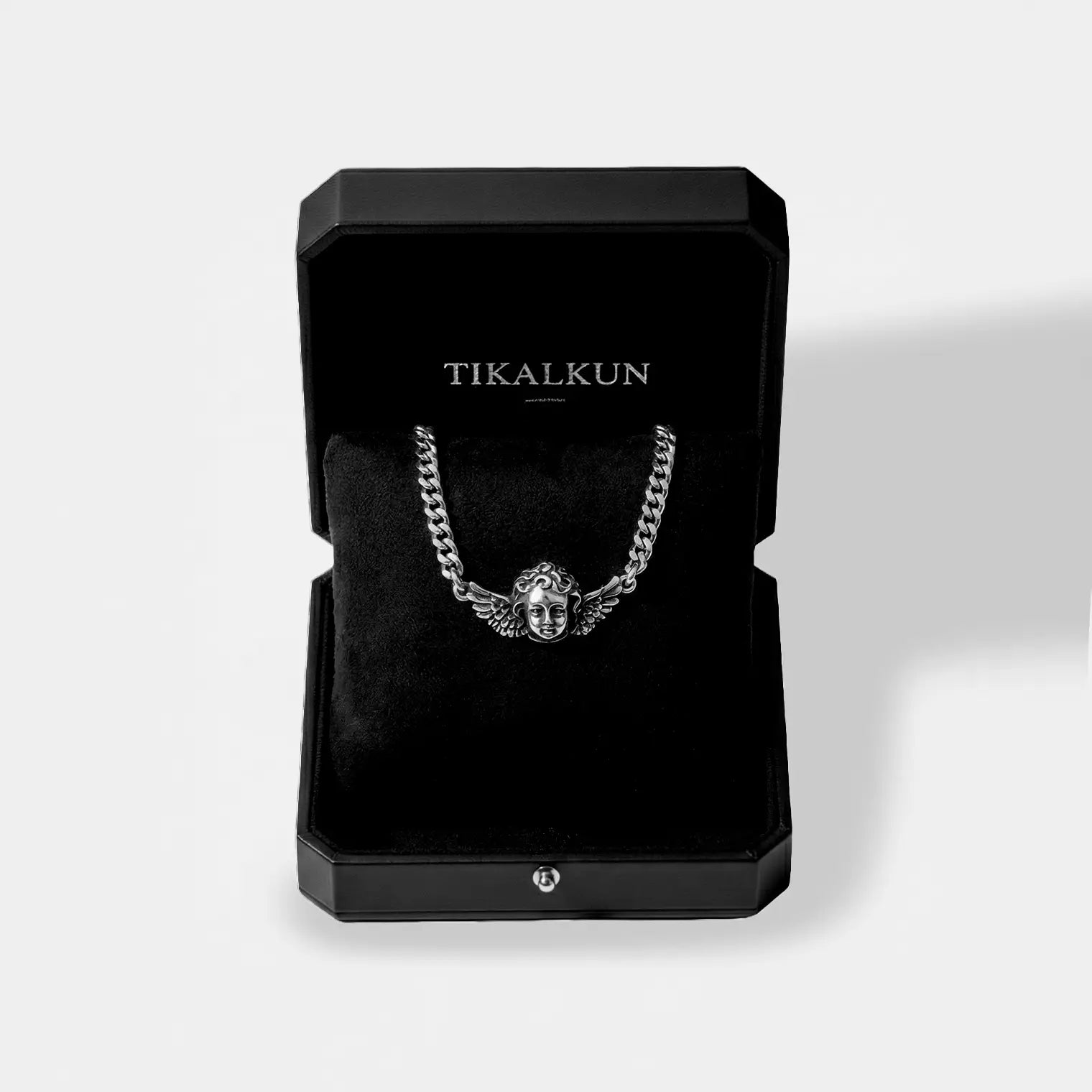 black "TIKALKUN" jewelry box with a cherub silver necklace inside