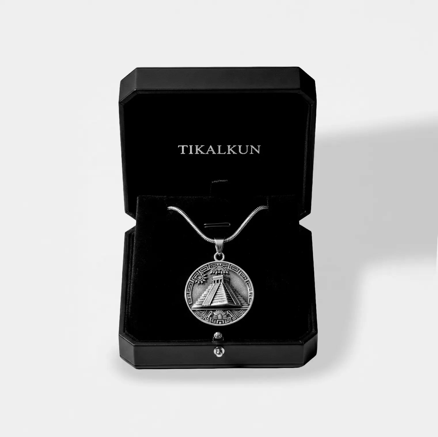 Silver pyramid necklace with a pendant in a black Tikalkun box on a light gray background