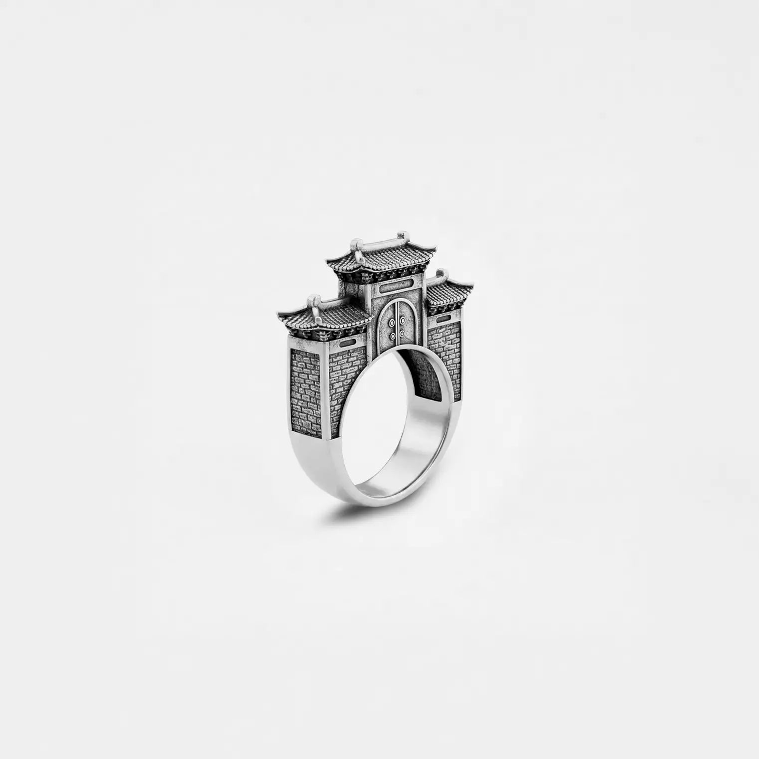 Silver ring with chinese architectural design on a white background