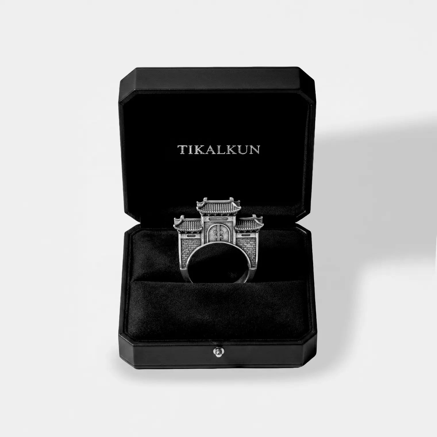 Silver ring with chinese architectural design in a black Tikalkun box on a light gray background