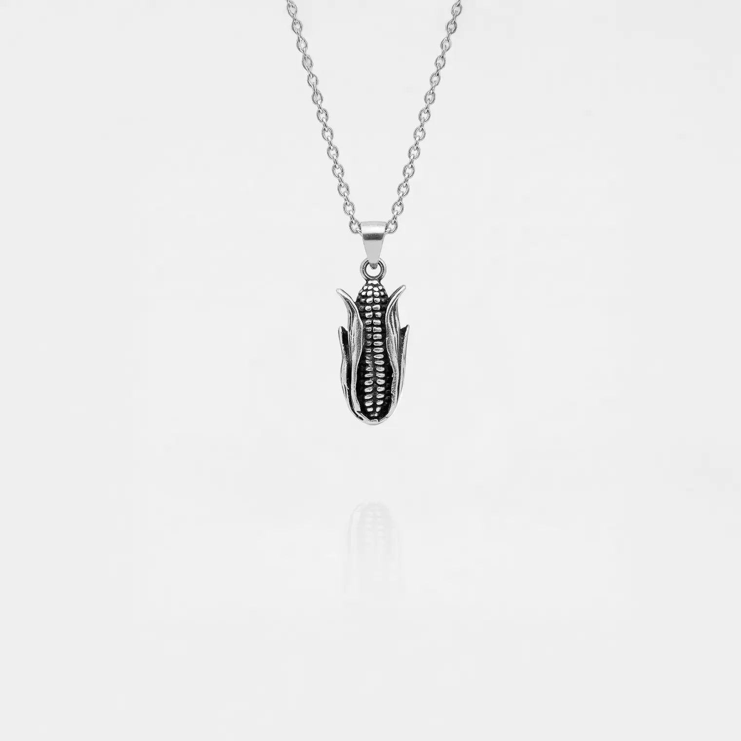 Silver corn cob pendant necklace on a white background