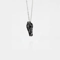 Silver necklace with a crocodile skull pendant on a white background