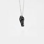 Silver necklace with a crocodile skull pendant on a white background
