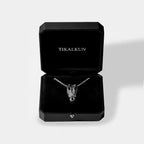 Silver necklace with crocodile skull design in a black Tikalkun box on a light gray background