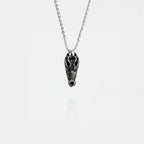 Silver necklace with a crocodile skull pendant on a white background