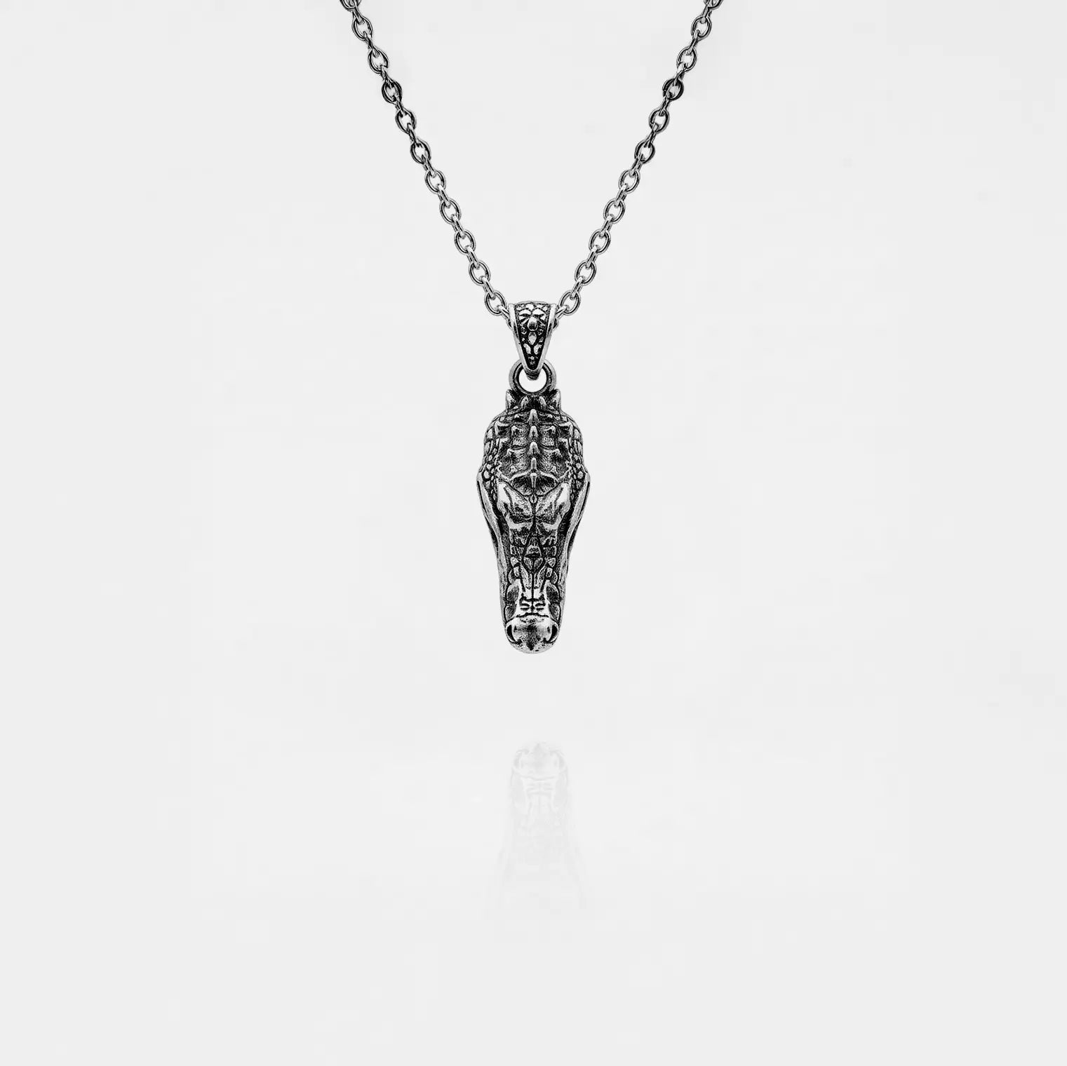 Silver crocodile pendant necklace on a white background