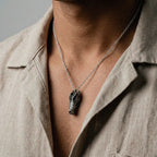 crocodile skull Necklace worn by a person wearing a beige shirt.