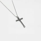 Silver cross necklace on a white background