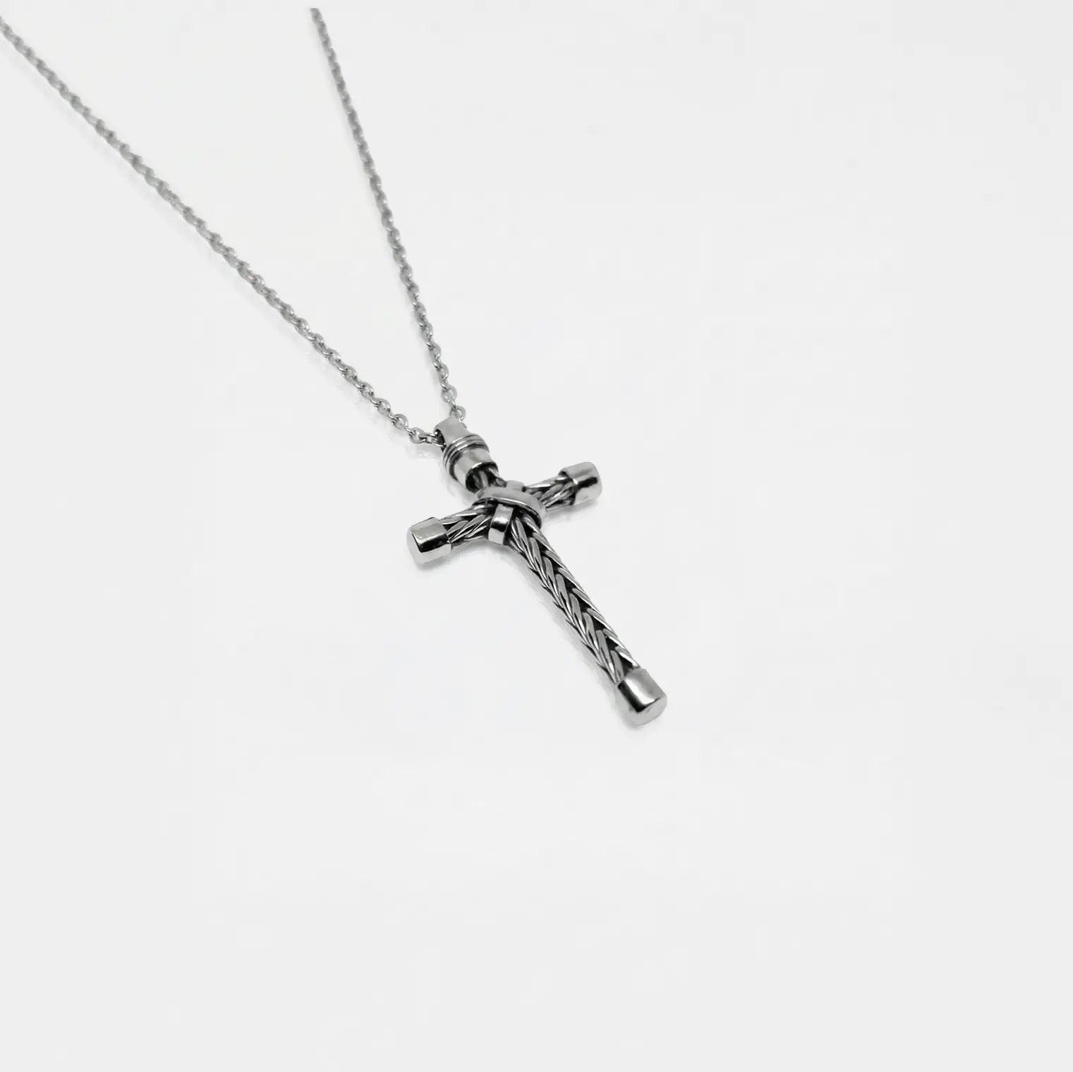 Silver cross necklace on a white background