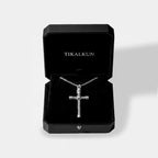 Silver cross necklace in a black Tikalkun jewelry box on a light gray background