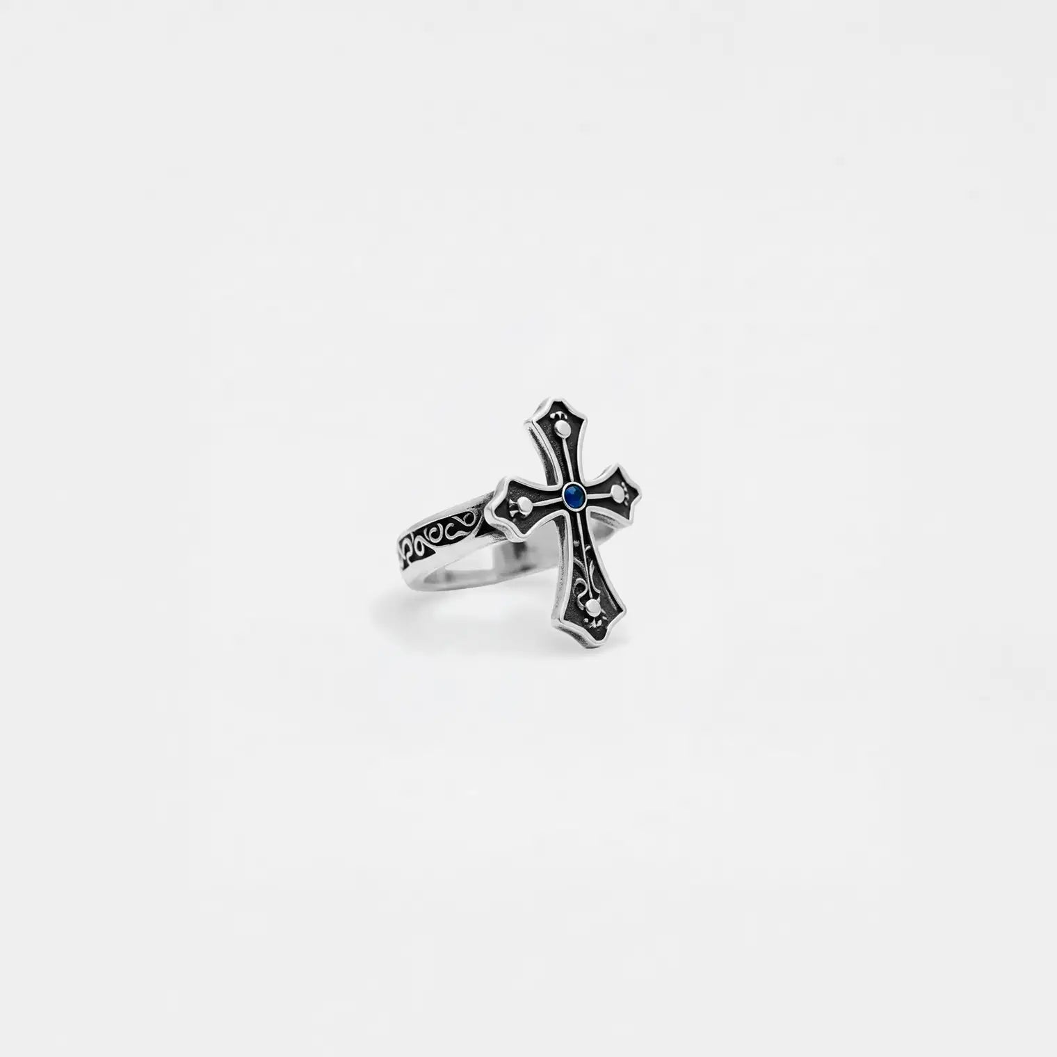 Silver cross ring with gemstone on a white background