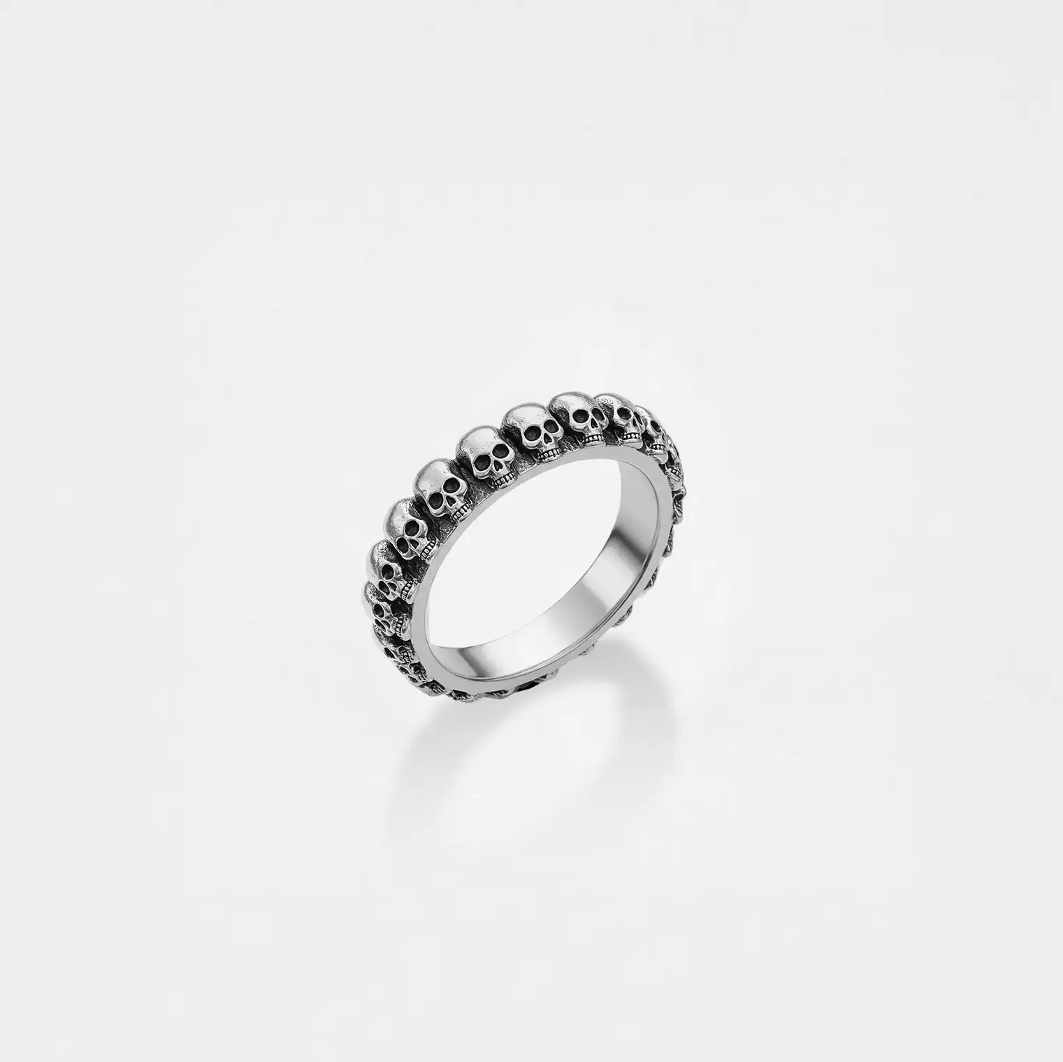 Silver ring with skull design on a light gray background