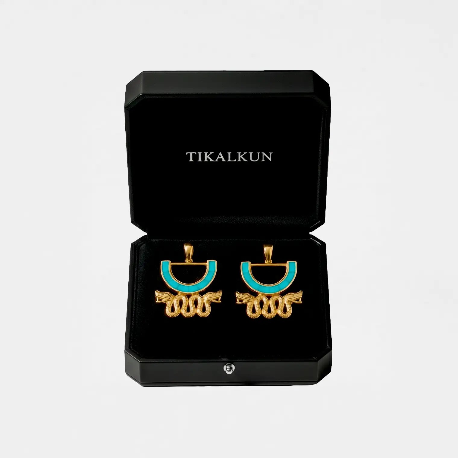 Gold and turquoise aztec earrings in a black Tikalkun box on a light gray background