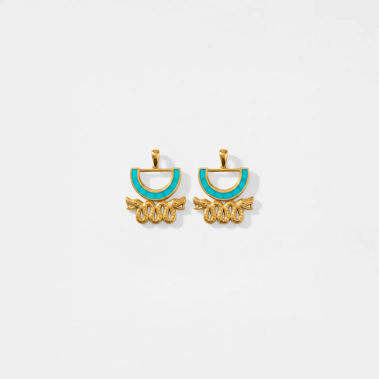 Gold and turquoise aztec earrings on a white background