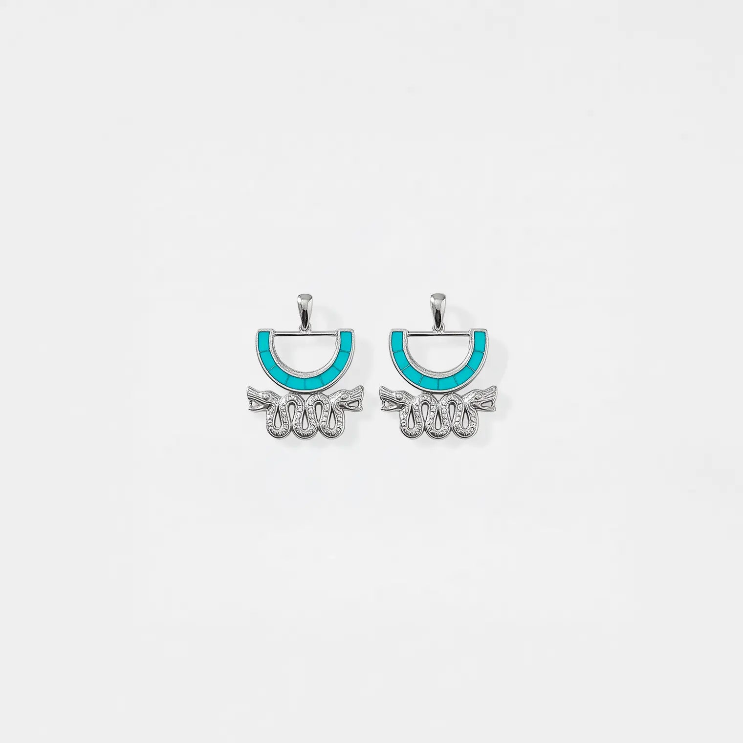 Pair of aztec earrings with turquoise accents on a white background