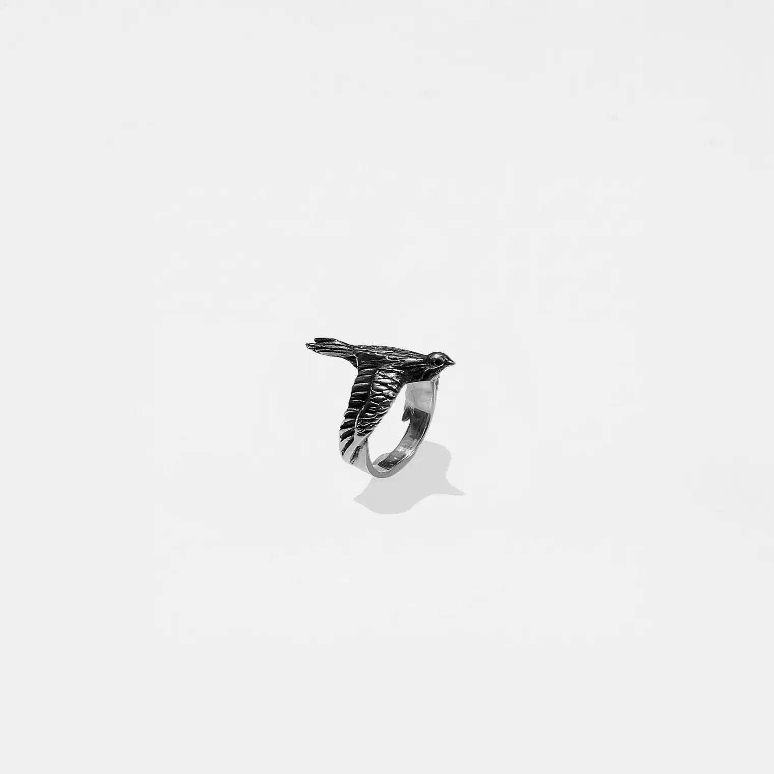 Silver ring with a dove design on a white background