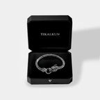 Silver bracelet with a dragon clasp in a black Tikalkun box on a light gray background